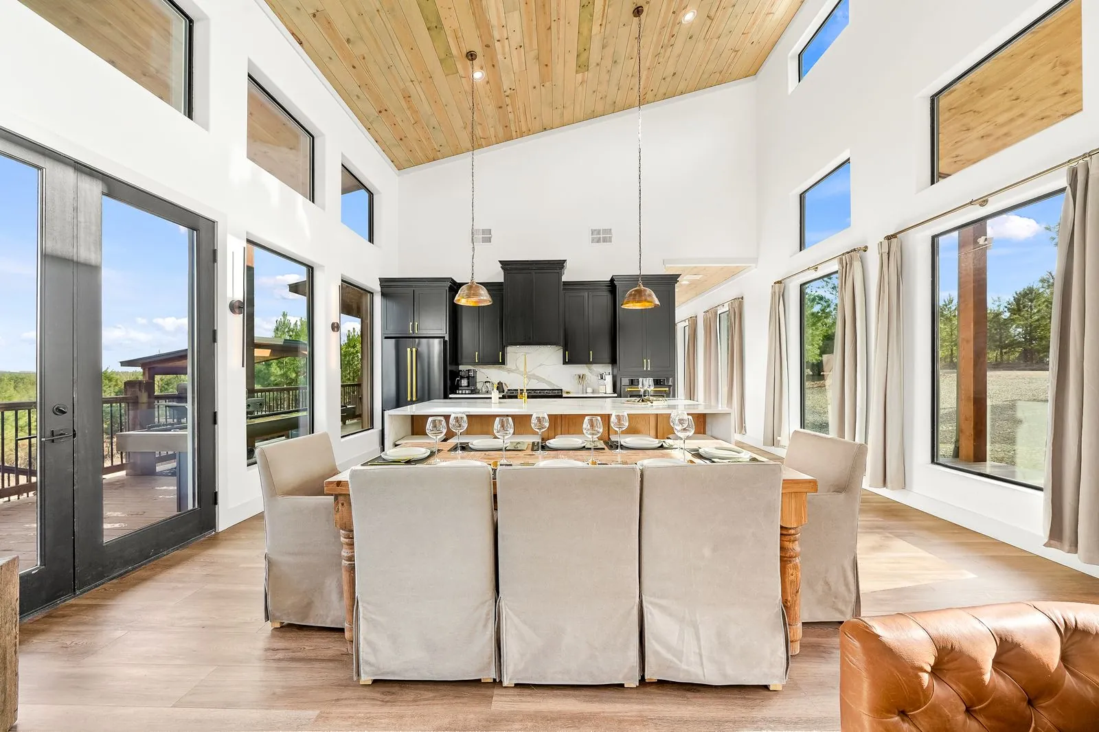 Wide kitchen panorama at The Malibu with vaulted wood ceiling, gold pendants, and abundant natural light from windows