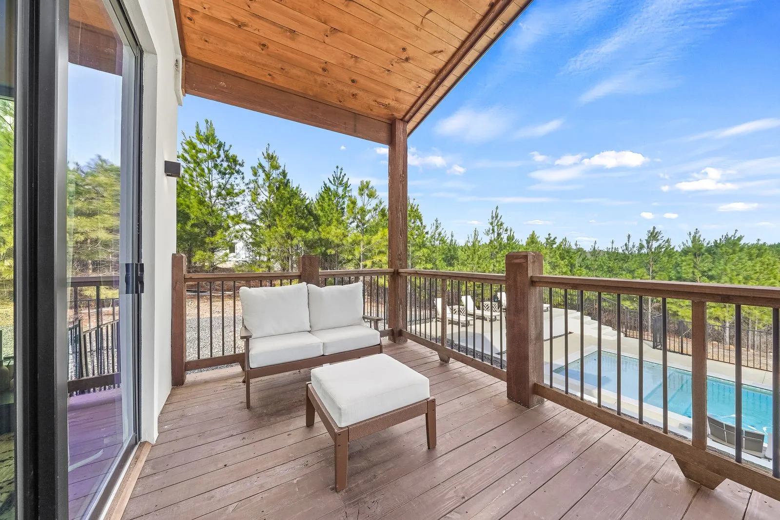 Dining area at The Malibu with slipcovered chairs, open sightline to living room with gold pendant and wood ceiling