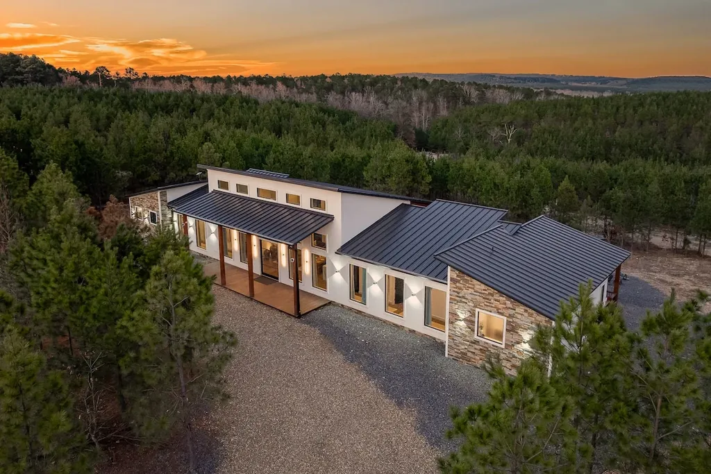 Aerial front view of The Malibu at sunset surrounded by forest