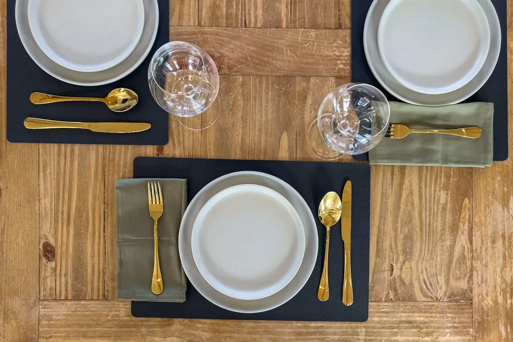 White-and-gold place settings on the wood dining table