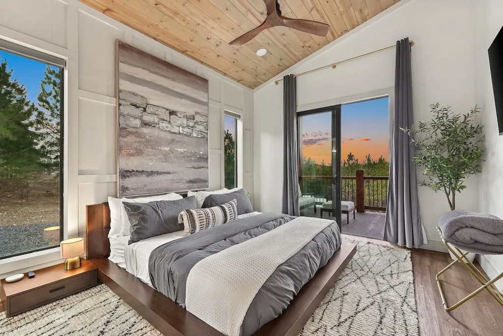King Bedroom 2 with stone artwork, tall windows, and private balcony