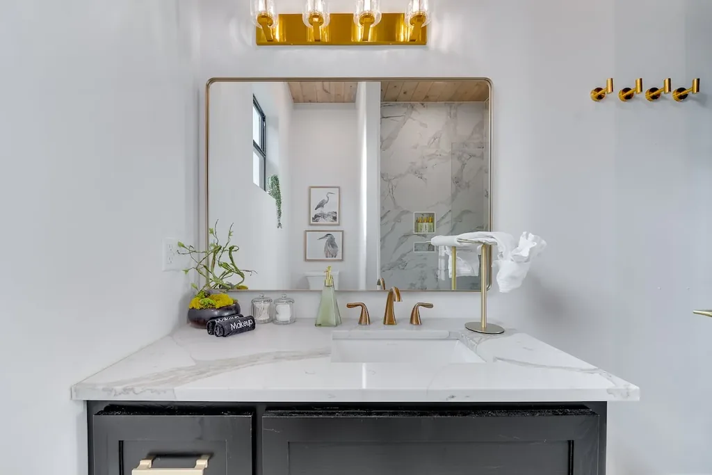 Full Bathroom 2 vanity with marble counter and gold fixtures