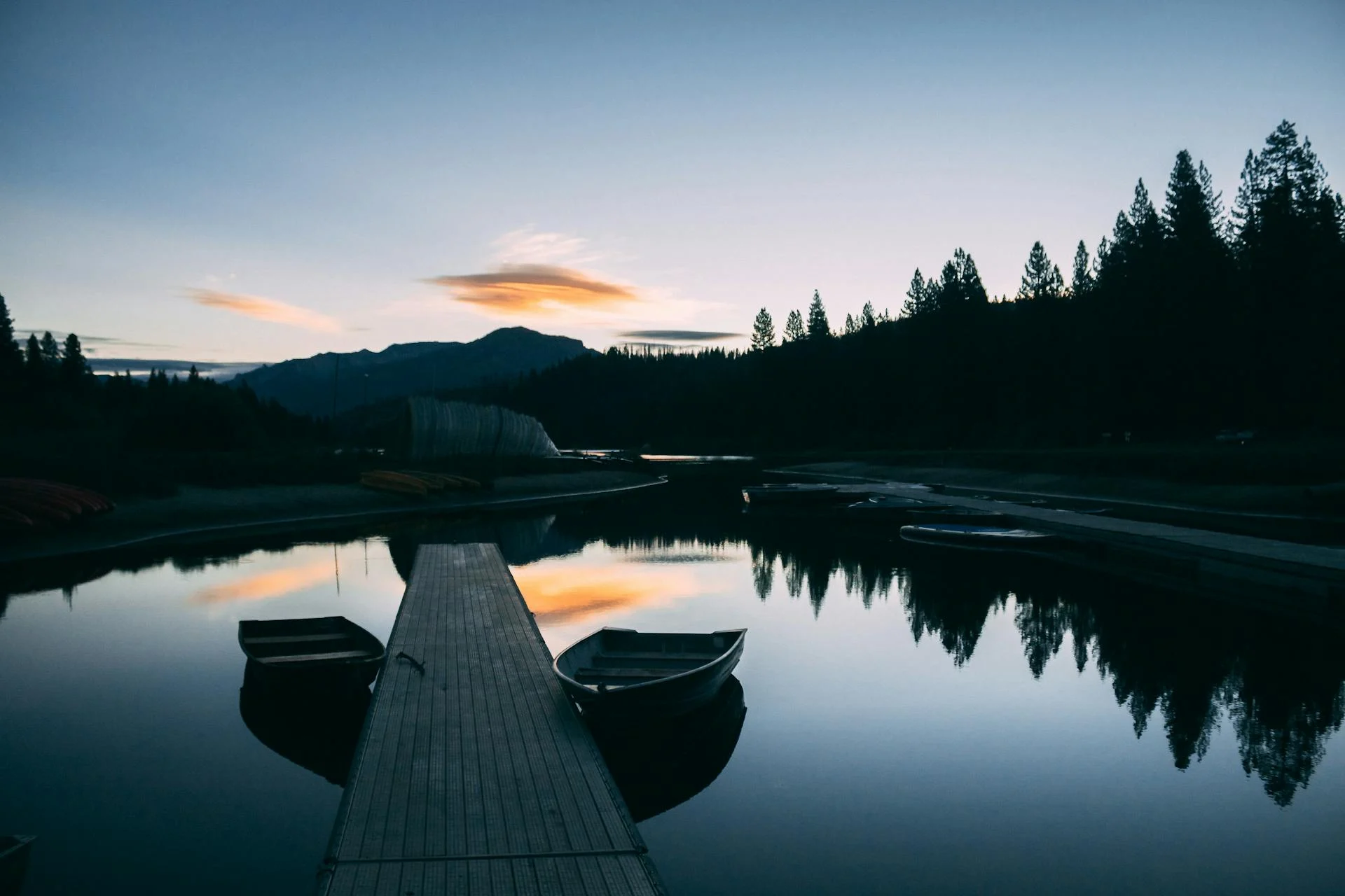 Two people canoeing on a calm lake at golden sunset
